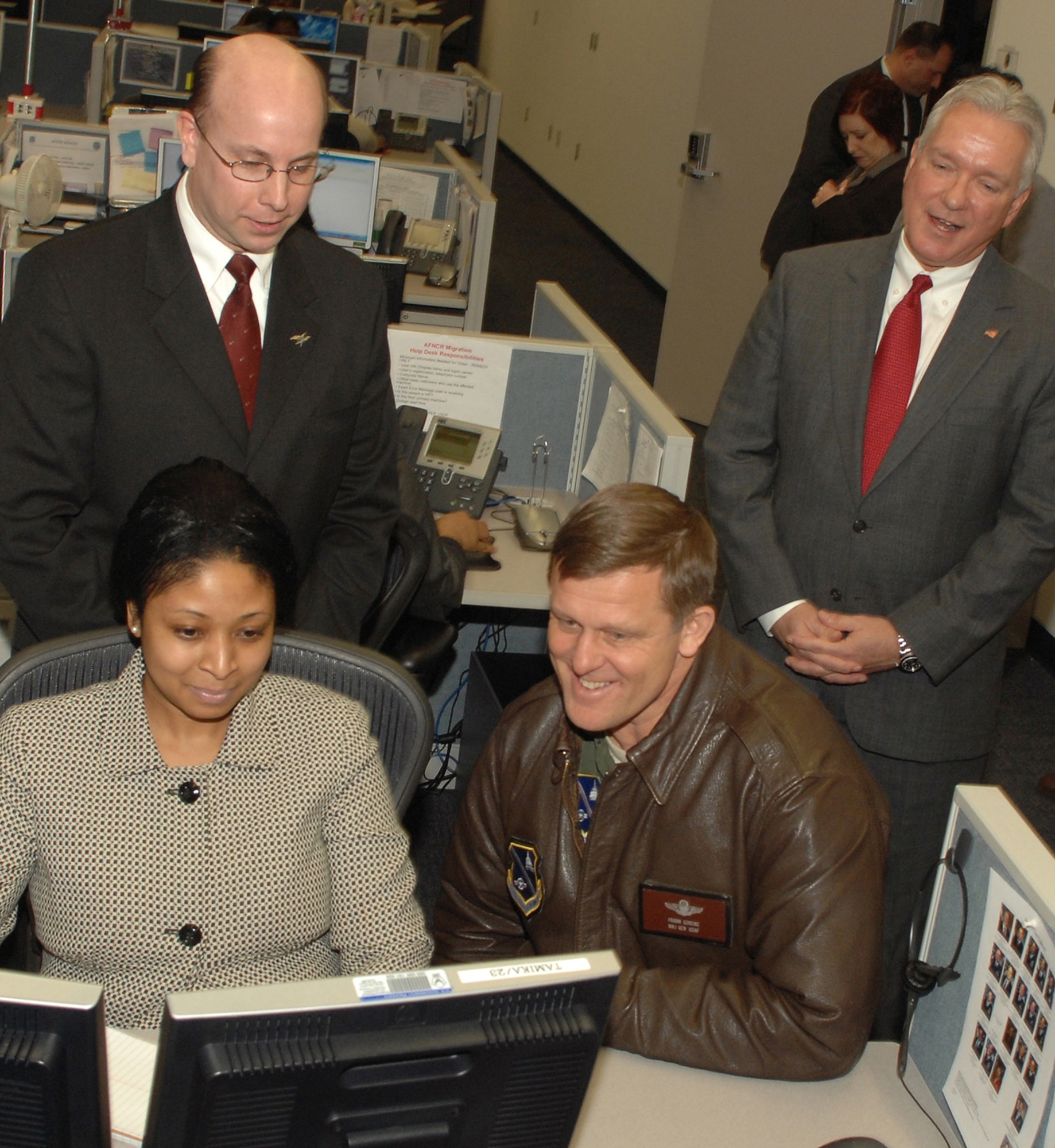 Maj. Gen. Frank Gorenc, Air Force District of Washington commander (seated right), gets a briefing on call center operations from Tamika Thompson, call center technician, (seated left) Feb. 29. Looking on are Kieht Harris, Lockheed Martin site manger (standing left) and Steve Lubniewski, president of Information Technology, Lockheed Martin (standing right). (U.S. Air Force photo by Senior Airman Tim Chacon)