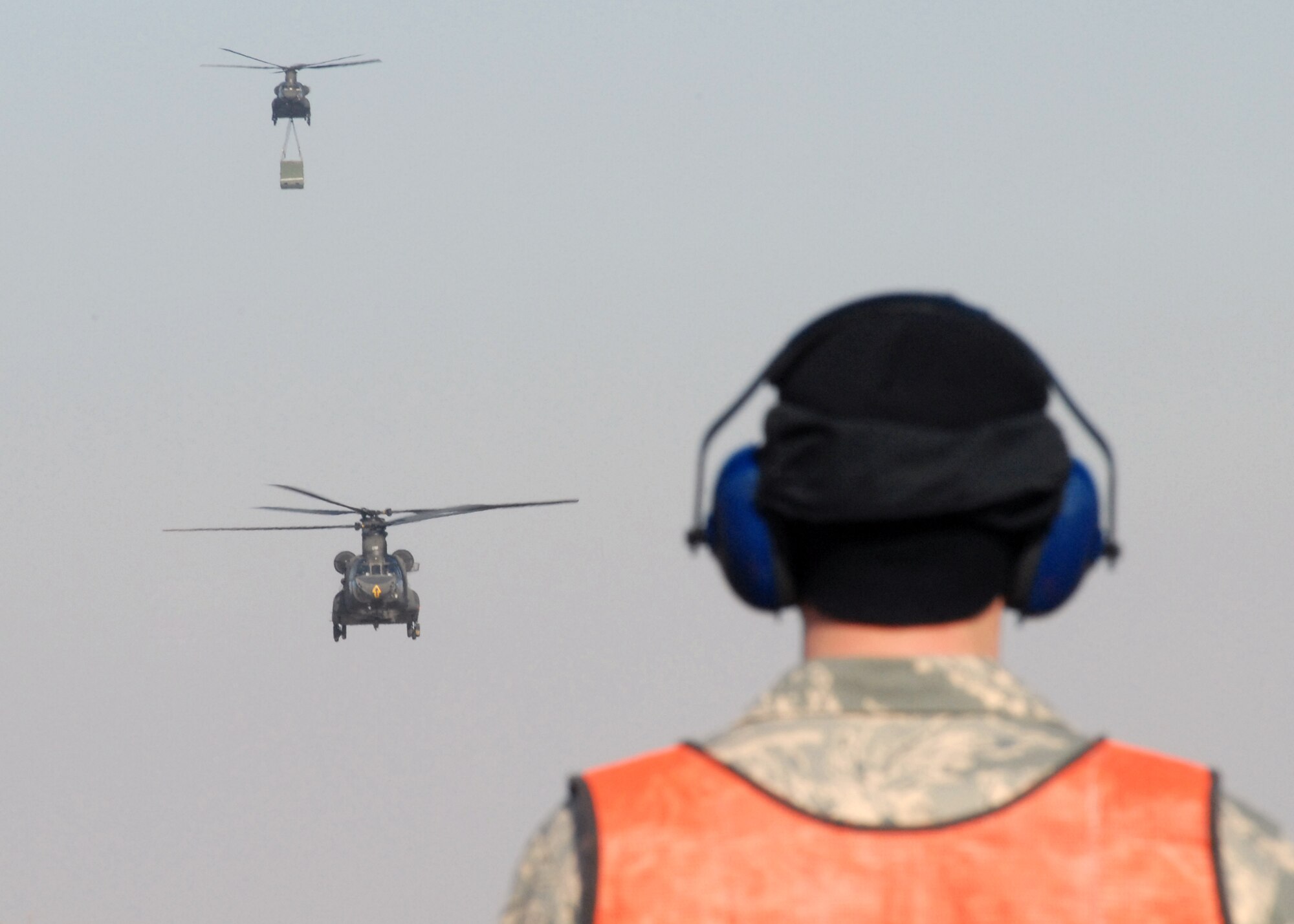 KUNSAN AIR BASE, South Korea -- Senior Airman Paul Epping, crew chief from the 8th Maintenance Squadron, stands by to marshal two CH-47 Chinook helicopters as they arrive here Mar. 1.  The Chinook's arrived from Camp Humphrey's, Bravo Company 4-2, as part of the Key Resolve/Foal Eagle exercise, enhancing combat readiness and joint interoperability.  (U.S. Air Force Photo/Staff Sgt Araceli Alarcon) 