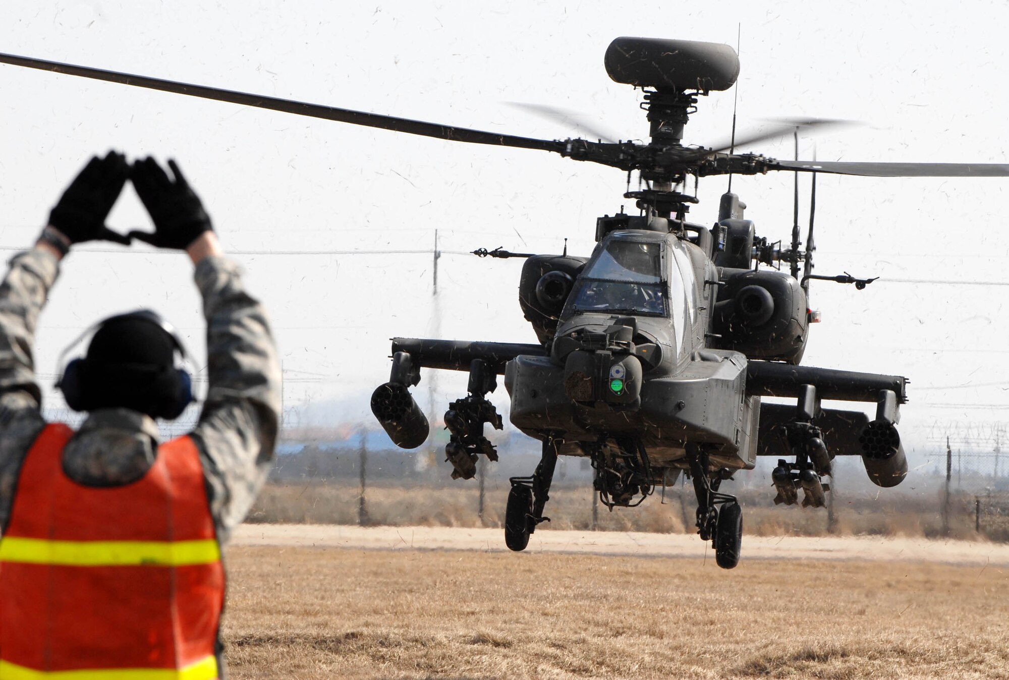 KUNSAN AIR BASE, South Korea -- Senior Airman Paul Epping, crew chief from the 8th Maintenance Squadron, marshal's in an AH-64 Apache helicopter here Mar. 1.  The Apache's arrived from Camp Humphrey's, Bravo Company 4-2, as part of the Key Resolve/Foal Eagle exercise, enhancing combat readiness and joint interoperability.  (U.S. Air Force photo/Senior Airman Steven R. Doty) 