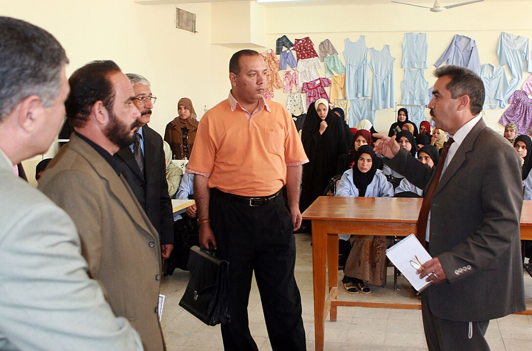 Nassir Abbas, director of the Iskandariyah Vocational School, speaks to Mahmudiyah Qada Education Director General Dr. Kais, Mahmudiyah Council Chairman Najim Mahdi al-Dulaymi and Sheik Somar Abdul Amir al-Anbari in a women’s sewing class during a tour of the school, March 2, 2008. Photo by Sgt. 1st Class Kerensa Hardy, USA