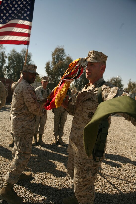 Lt. Col. David Nathanson, commanding officer of Combat Logistics Battalion 1, 1st Marine Logistics Group, unveils the battalion guidon during a transfer-of-authority ceremony in Camp Fallujah Mar. 5. CLB-8 turned responsibilities over to CLB-1, based out of Camp Pendleton, Calif., and is scheduled to return to the United States by mid-March. They completed more than 330 resupply missions during their seven-month deployment, delivering nearly a million gallons of fuel and 500,000 gallons of water to Regimental Combat Team 6 and RCT-1. They also emplaced about 10 million tons of concrete barriers, making their area safer for coalition and Iraqi forces.