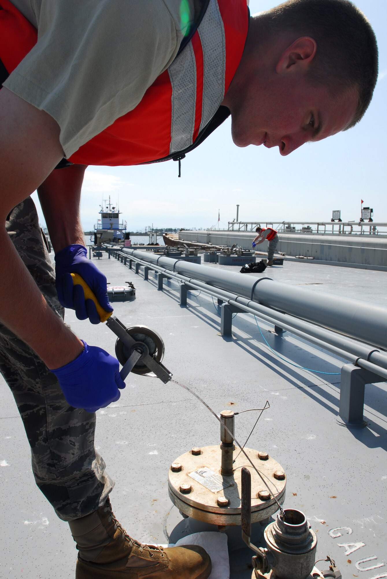Senior Airman Richard Aring (left), 1st Special Operations Logistics Readiness Squadron, checks the depth of the fuel stored inside a barge while Staff Sgt. Curtis Prather (right), 1st SOLRS, takes a fuel sample at the fuel pier on Hurlburt Field March 6. The newly constructed, $5.3 million fuel pier accepted its first barge March 6. The fuel pier pumps fuel to Hurlburt Field through an underground pipe, which will greatly increase the efficiency of delivering fuel to the base. The old fuel pier was destroyed during Hurricane Ivan in September 2004. (U.S. Air Force photo/Airman 1st Class Jason Epley)
