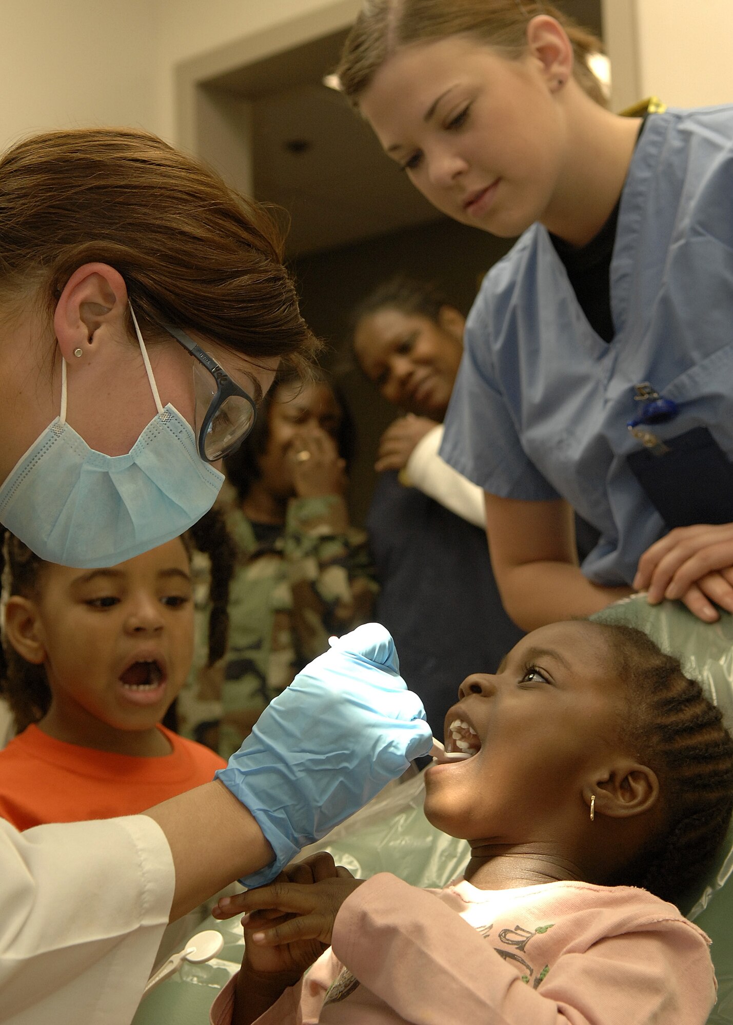 Capt. Sara Hale, 61st Medical Group, takes a look at three year old Nia Adeogun’s teeth during Dental Awareness Week at the base dental clinic, Feb. 27. (Photo by Stephen Schester)