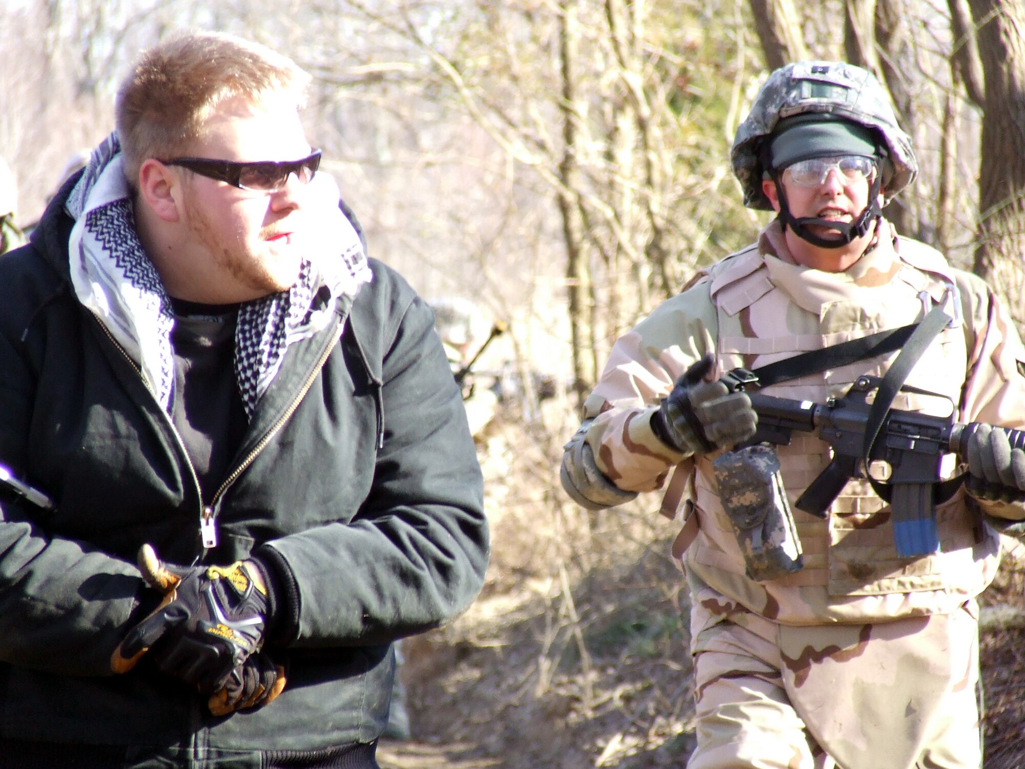 Capt. Scott Jensen leads a "patient" through the combat first aid obstacle course on a range on Fort Dix, N.J., Feb. 29, 2008, as part of training in the U.S. Air Force Expeditionary Center's Air Advisor Course 08-1.  The course, taught by the Center's Expeditionary Operations School, is the first of its kind for the Center and is preparing Airmen deploying to Afghanistan and Iraq who will in turn be training military forces in those countries.  (U.S. Air Force Photo/Tech. Sgt. Scott T. Sturkol)