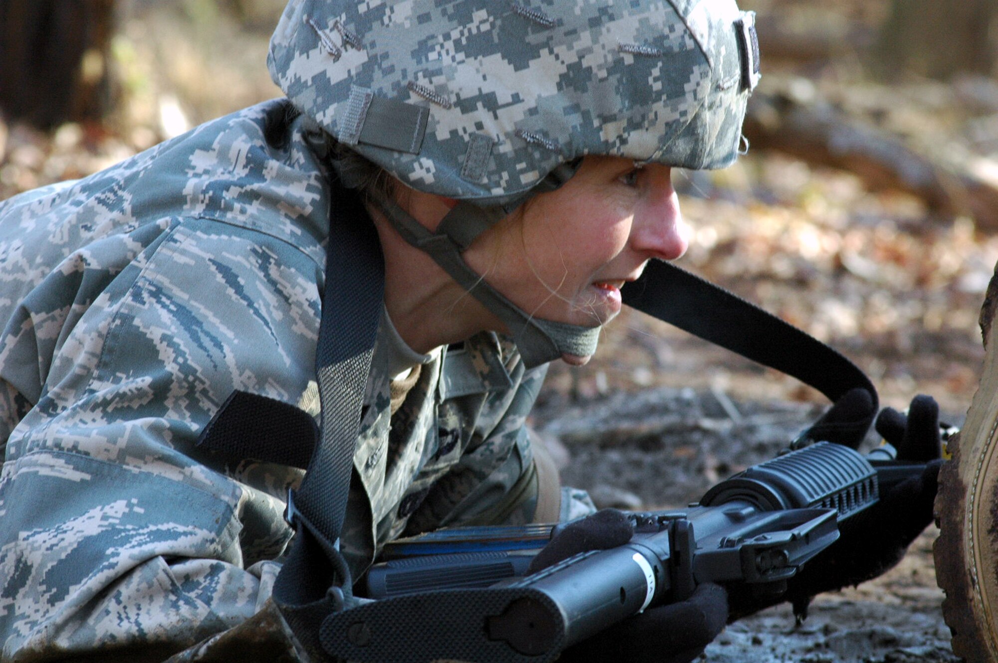 Capt. Dawn Fitzgerald goes through the combat first aid obstacle course on a range on Fort Dix, N.J., Feb. 29, 2008, as part of training in the U.S. Air Force Expeditionary Center's Air Advisor Course 08-1.  The course, taught by the Center's Expeditionary Operations School, is the first of its kind for the Center and is preparing Airmen deploying to Afghanistan and Iraq who will in turn be training military forces in those countries.  Sergeant Bookman is from Lackland Air Force Base, Texas.  Captain Fitzgerald is from Nellis Air Force Base, Nev.  (U.S. Air Force Photo/Tech. Sgt. Scott T. Sturkol)
