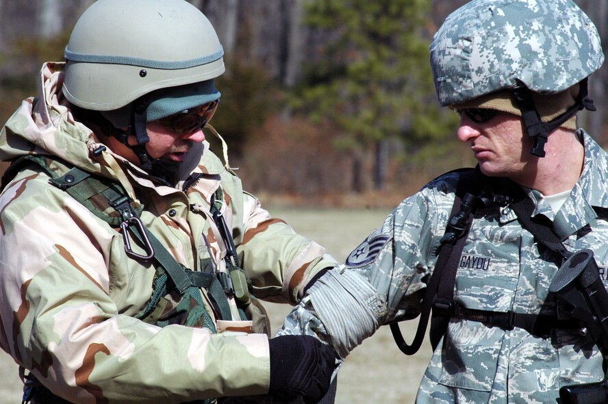 Master Sgt. Brian Gordon and Tech. Sgt. Travis Gayou, both students in the U.S. Air Force Expeditionary Center's Air Advisor Course 08-1, practice putting on bandages as part of training in the combat first aid obstacle course on a range on Fort Dix, N.J., Feb. 29, 2008.  The course, taught by the Center's Expeditionary Operations School, is the first of its kind at the Center and is preparing Airmen for deployments to Afghanistan and Iraq where they will be training host nation military forces.  (U.S. Air Force Photo/Tech. Sgt. Scott T. Sturkol)