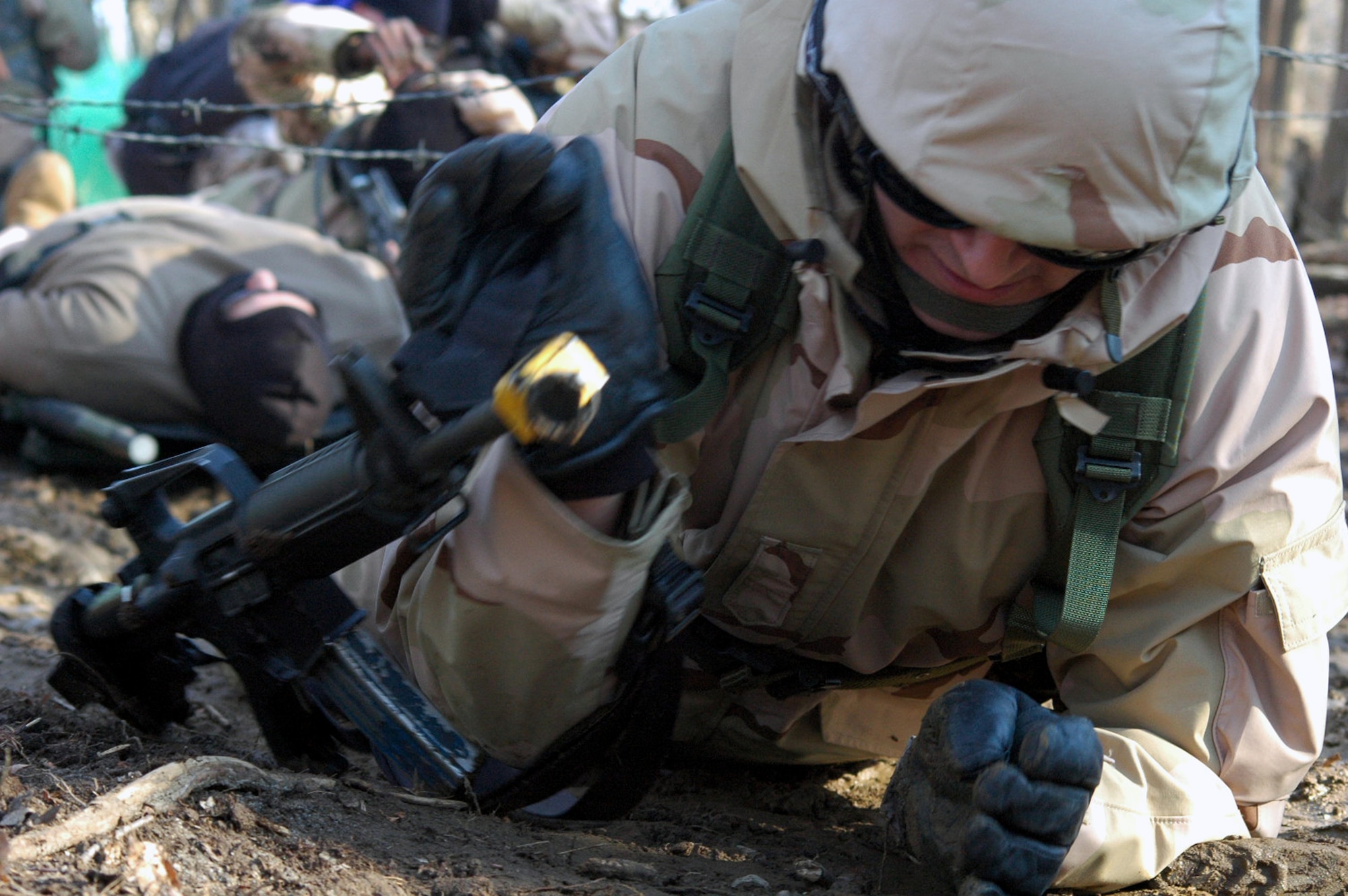 Students in the U.S. Air Force Expeditionary Center's Air Advisor Course 08-1 crawl under barbed wire as part of their training in the combat first aid obstacle course during training on a range on Fort Dix, N.J., Feb. 29, 2008.  The course, taught by the Center's Expeditionary Operations School, is the first of its kind at the Center and is preparing Airmen for deployments to Afghanistan and Iraq where they will be training host nation military forces.  (U.S. Air Force Photo/Tech. Sgt. Scott T. Sturkol)