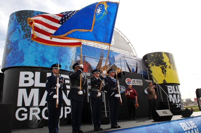 LAS VEGAS-- Members of the Nellis Air Force Base Honor Guard present the colors while singer and former U.S. Marine and American Idol star Joshua Gracin sings the National Anthem during opening ceremonies of the Sam's Town 300 here March 1. For more than a decade, the Nellis AFB community and Las Vegas Motor Speedway family have enjoyed a cooperative relationship that both thrills race fans and emblazons the patriotic spirit of America. (U.S. Air Force photo/Master Sgt Robert W. Valenca)