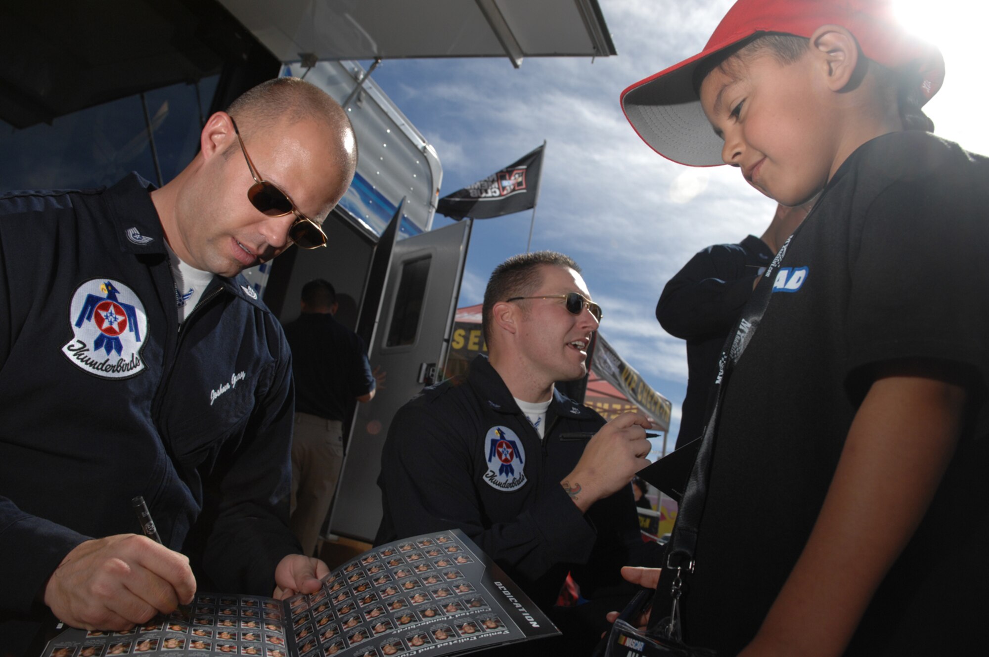 LAS VEGAS--Tech Sgt. Joshua Gray, U.S. Air Force Aerial Demonstration Team, the Thunderbirds, signs an autograph for Dominic Sandavol from San Diego, Calif., while outside the Las Vegas Motor Speedway during the Nationwide Series Sam's Town 300 here March 1. For more than a decade, the Nellis AFB community and Las Vegas Motor Speedway family have enjoyed a cooperative relationship that both thrills race fans and emblazons the patriotic spirit of America. (U.S. Air Force photo/Master Sgt Robert W. Valenca)