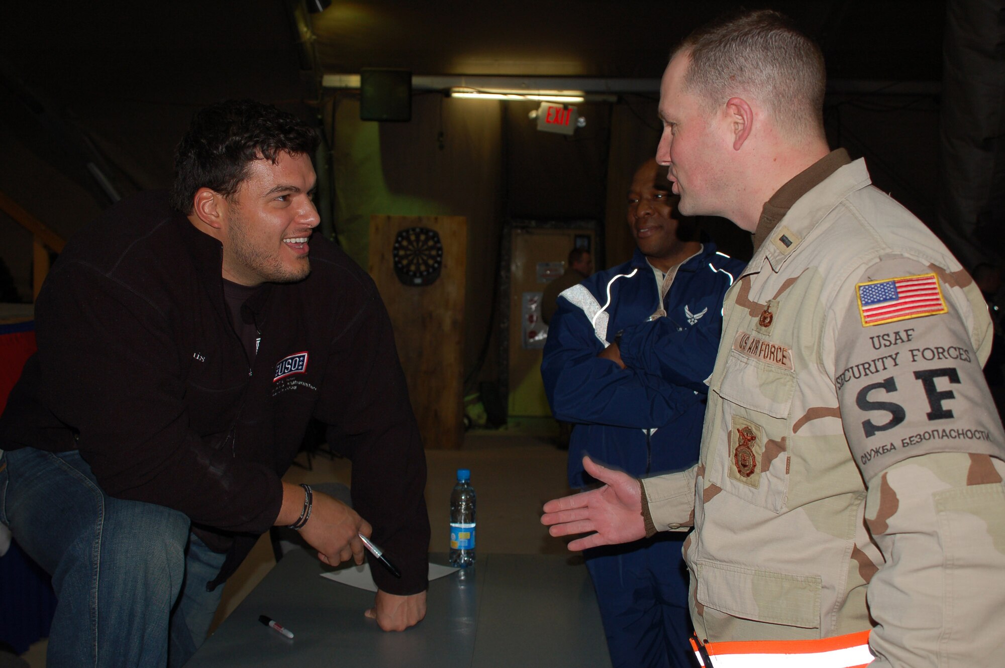 San Diego Chargers Luis Castillo chats with 1st Lt. Steven Falusi March 4 at the recreation center on Manas Air Base, Kyrgyzstan. Castillo, Chicago Bears Tommie Harris, Carolina Panthers Mike Rucker and Sports Illustrated writer Peter King took part in the United Service Organizations National Football League tour to visit servicemembers supporting the war. Lieutenant Falusi, assigned to the 376th Expeditionary Security Forces Squadron, is a Connecticut Air National Guard member. (U.S. Air Force photo/Lt. Col. Adriane Craig) 
