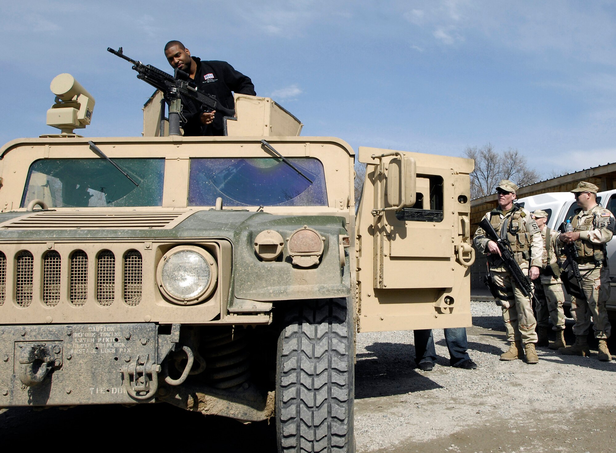 Carolina Panthers Mike Rucker checks out a M-240B machine gun on a 376th Expeditionary Security Forces Squadron Humvee March 4 at Manas Air Base, Kyrgyzstan. Mr. Rucker, Chicago Bears Tommie Harris, San Diego Chargers Luis Castillo and Sports Illustrated writer Peter King visited Airmen at the base as part of the United Service Organizations NFL Tour to show support of operations in Afghanistan . (U.S. Air Force photo/Senior Airman Tabitha Kuykendall) 
