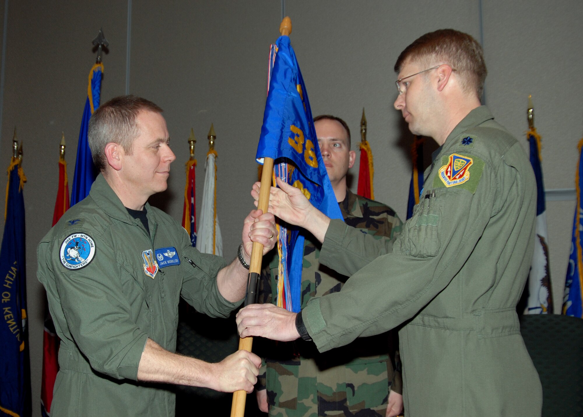 NAVAL AIR STATION WHIDBEY ISLAND, Wash. - Lt. Col. Eric Johnson passes the 388th Electronic Combat Squadron flag to Col. John McMullen, 366th Operations Group commander, as he relinquishes command during a change of command ceremony for the 388th Electronic Combat Squadron held at the Officer's Club on Naval Air Station Whidbey Island, Wash., Mar. 4. Lt. Col. William Young Jr. assumed command of the 388th ECS from Colonel Johnson at the ceremony. The change of command ceremony is a time-honored tradition that formally restates to the officers and enlisted personnel of the command the continuity of the authority of command. (U.S. Navy Photo by Mass Communication Specialist 2nd Class Tucker M. Yates)