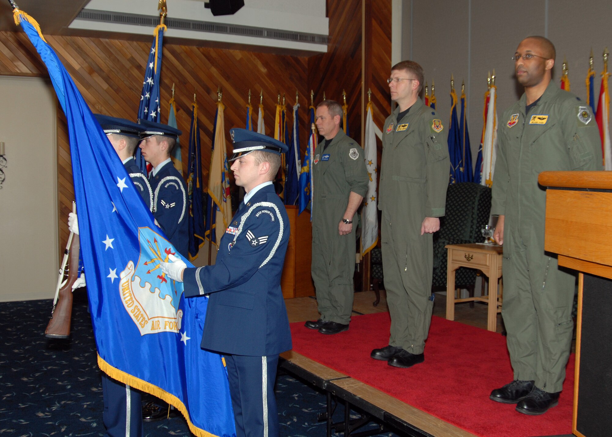 NAVAL AIR STATION WHIDBEY ISLAND, Wash. -- The official party stands at attention during the singing of the National Anthem during a change of command ceremony for the 388th Electronic Combat Squadron held at the Officer's Club on Naval Air Station Whidbey Island, Wash., Mar. 4. Lt. Col. Eric Johnson relinquished command of the squadron to Lt. Col. William Young Jr. at the ceremony. The change of command ceremony is a time-honored tradition that formally restates to the officers and enlisted personnel of the command the continuity of the authority of command. (U.S. Navy Photo by Mass Communication Specialist 2nd Class Tucker M. Yates)