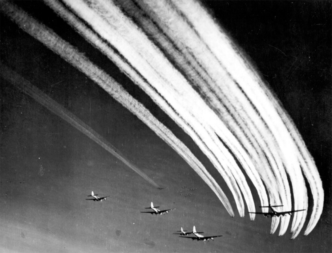 B-17 vapor trails fill the sky as a flight of B-17s join with other flights for a long range mission. 
