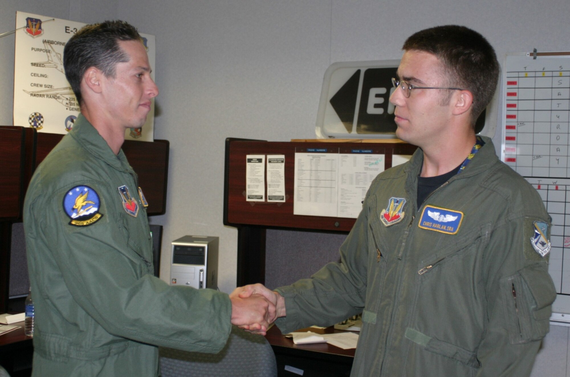 Senior Airman Chris Harlan is congratulated by one of his supervisors, Staff Sgt. Jason Malin, for his heroic act.
