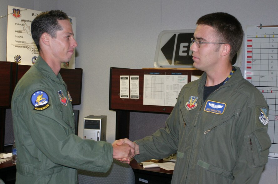 Senior Airman Chris Harlan is congratulated by one of his supervisors, Staff Sgt. Jason Malin, for his heroic act.
