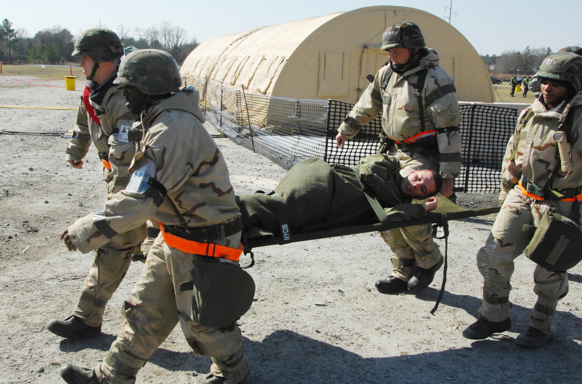 SrA Anthony Guthrie, SrA Courtney Braddock,TSgt Jeff Jordon and SSgt A'Keela Fitch transport "victim" A1C Carlos Rivera to the first aid tent. U. S. Air Force photo by Claude Lazzara