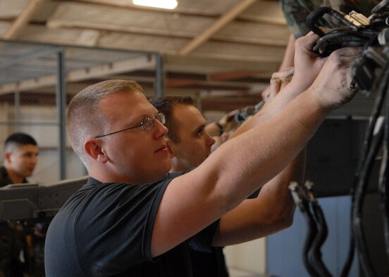 Senior Airman Donald Ballard and Staff Sgt. Jed Hall, aircraft armament assistant specialists with the 309th Aircraft Maintanence Unit, replaces faulty wiring on the right wing of an F-16, Mar. 3, Luke Air Force Base, Ariz. (U.S. Air Force photo/Staff Sgt. Jerry Fleshman)