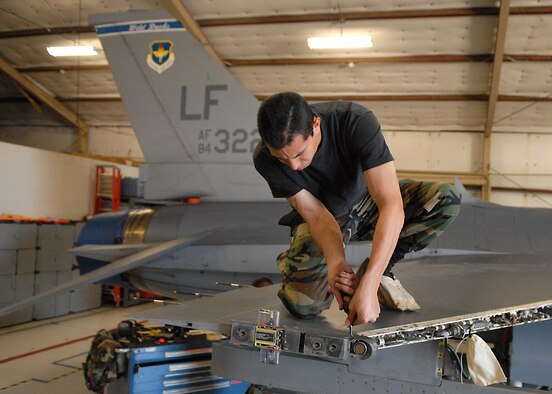 Staff Sgt. Jose Arreola, aircraft armament assistant specialist with the 309th Aircraft Maintenance Unit, Luke Air Force Base, Ariz., replaces worn out wires on the right wing of an F-16, Mar. 3. (U.S. Air Force photo/Staff Sgt. Jerry Fleshman) 