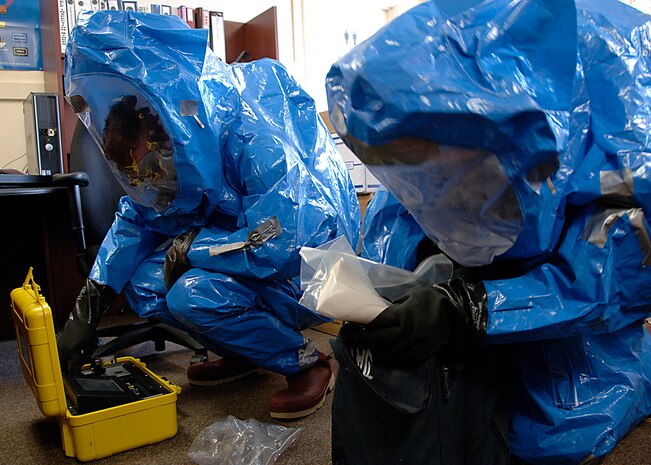 Senior Airmen Casey Love and Levi Lux identify an unknown powder in a suspicious package at the Charleston AFB Post Office Monday during a biological/radiological response exercise. Airman Love is an emergency manager with the 437th Civil Engineer Squadron and Airman Lux is a bio-environmental specialist with the 437th Medical Group.  (U.S. Air Force photo/Airman 1st Class Katie Gieratz)
