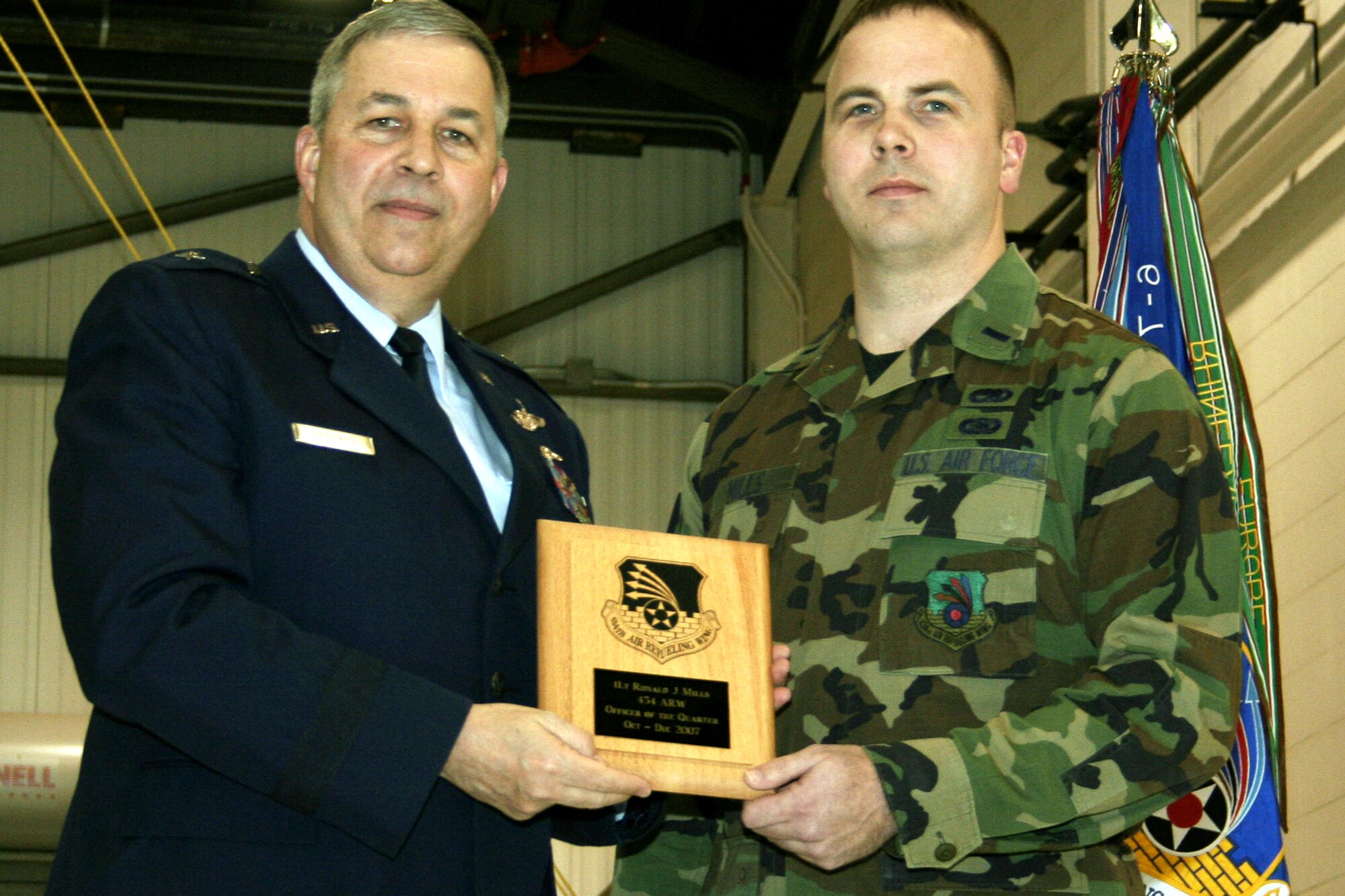 GRISSOM AIR RESERVE BASE, Ind., -- Brig. Gen. Dean Despinoy, 434th Air Refueling Wing commander, left, presents 1st Lt. Ronald Mills, 434th Aircraft Maintenance Squadron, a plaque for his selection as the wing's Officer of the Quarter during a commander's call held on the March unit training assembly.  (U.S. Air Force photo/Tech. Sgt. Patrick Kuminecz)