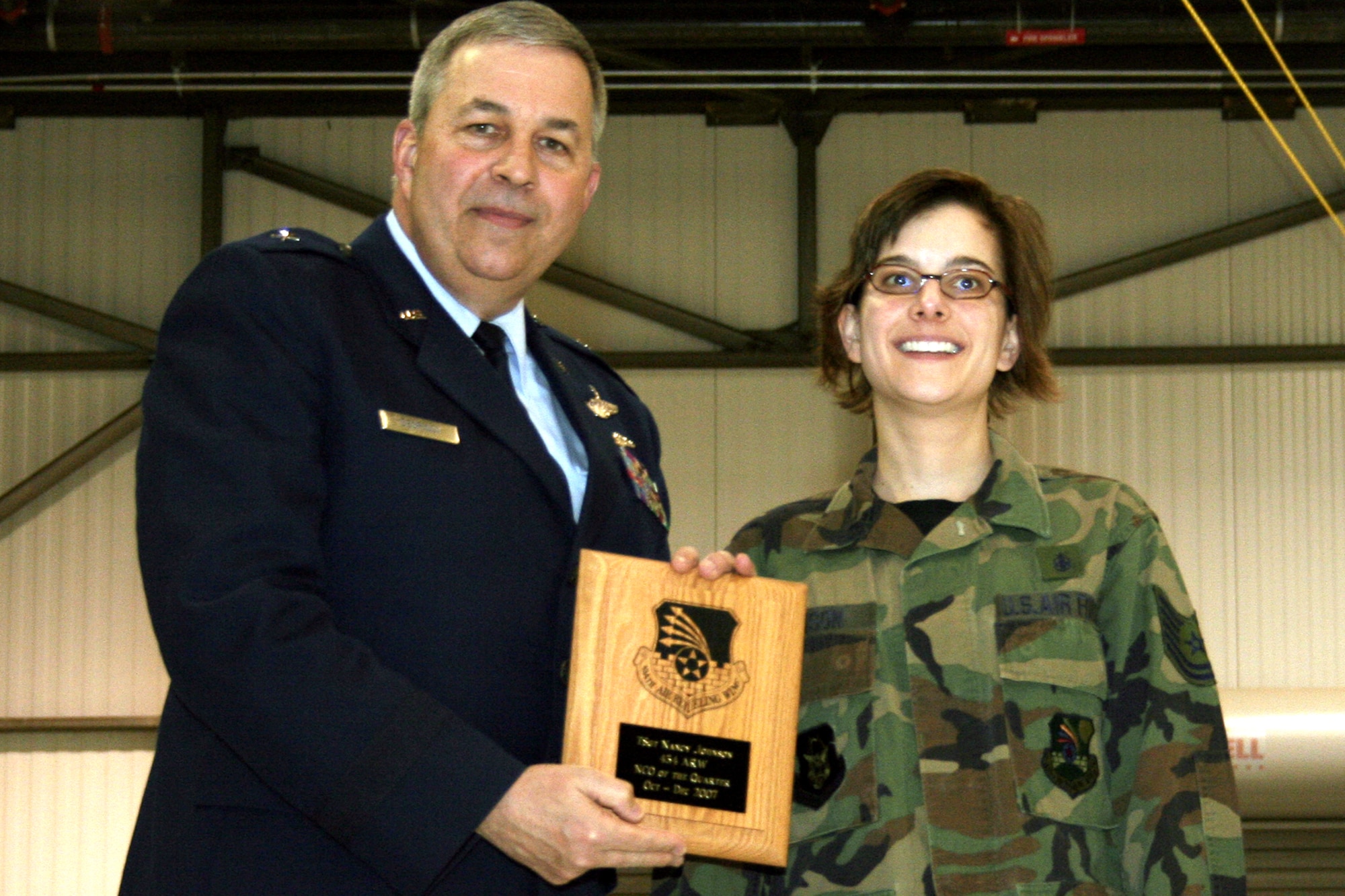 GRISSOM AIR RESERVE BASE, Ind., -- Brig. Gen. Dean Despinoy, 434th Air Refueling Wing commander, presents Tech. Sgt. Nancy Johnson, 434th Aerospace Medicine Squadron, a plaque for her selection as Grissom's NCO of the Quarter. (U.S. Air Force photo/Tech. Sgt. Patrick Kuminecz)