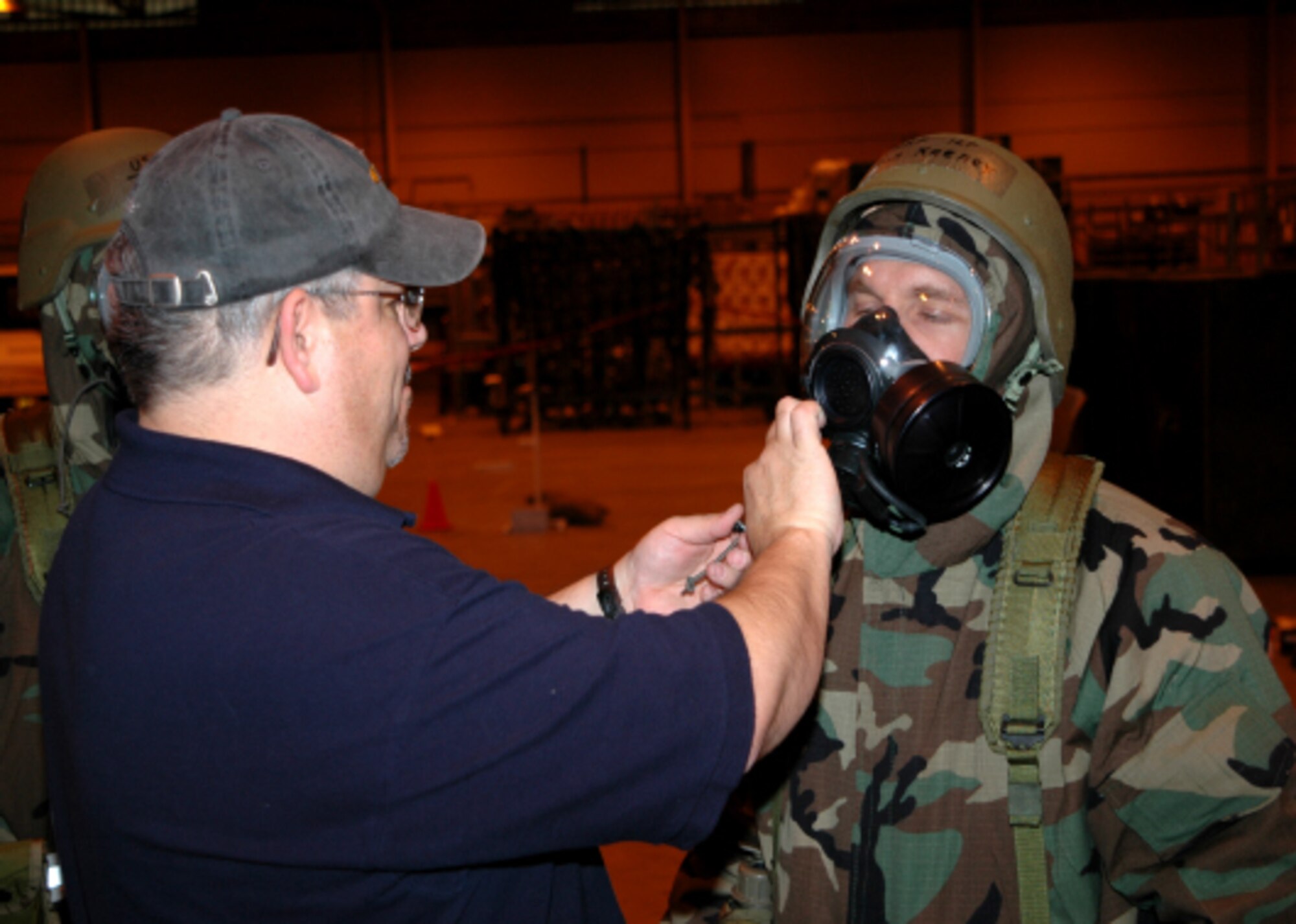 Robert Wydock, an emergency management technician with the 434th Civil Engineers Squadron, assists one of thirty personnel involved in the skills demonstration portion of the new CBRNE Defense Skills course.  The activity is the second part of a new Air Force wide approach to chemical, biological, radiological, nuclear and explosive defense protection. (U.S. Air Force photo/Senior Airman Chris Bolen)