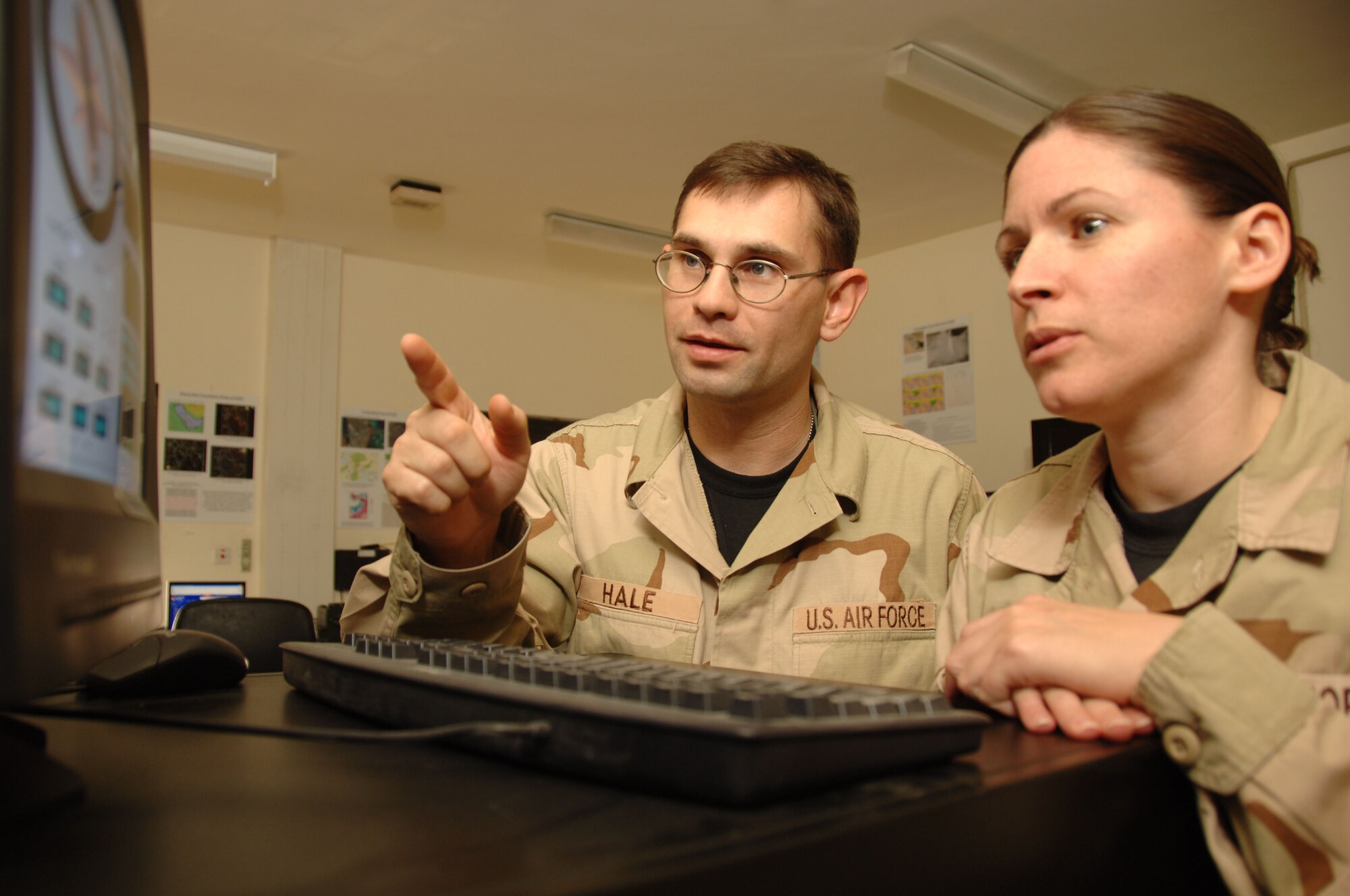 Tech. Sgt. Travis Hale points our current weather conditions on an automated observing system to Tech. Sgt. Elizabeth Covairt, to make sure aircrews have the most current information for flying safety. Weather conditions are updated every minute by sensors on both ends of the runway. Sergeant Hale is deployed from Dyess Air Force Base, Texas; Sergeant Covairt is from Beale Air Force Base, Calif. (U.S. Air Force photo/Senior Airman Tong Duong)