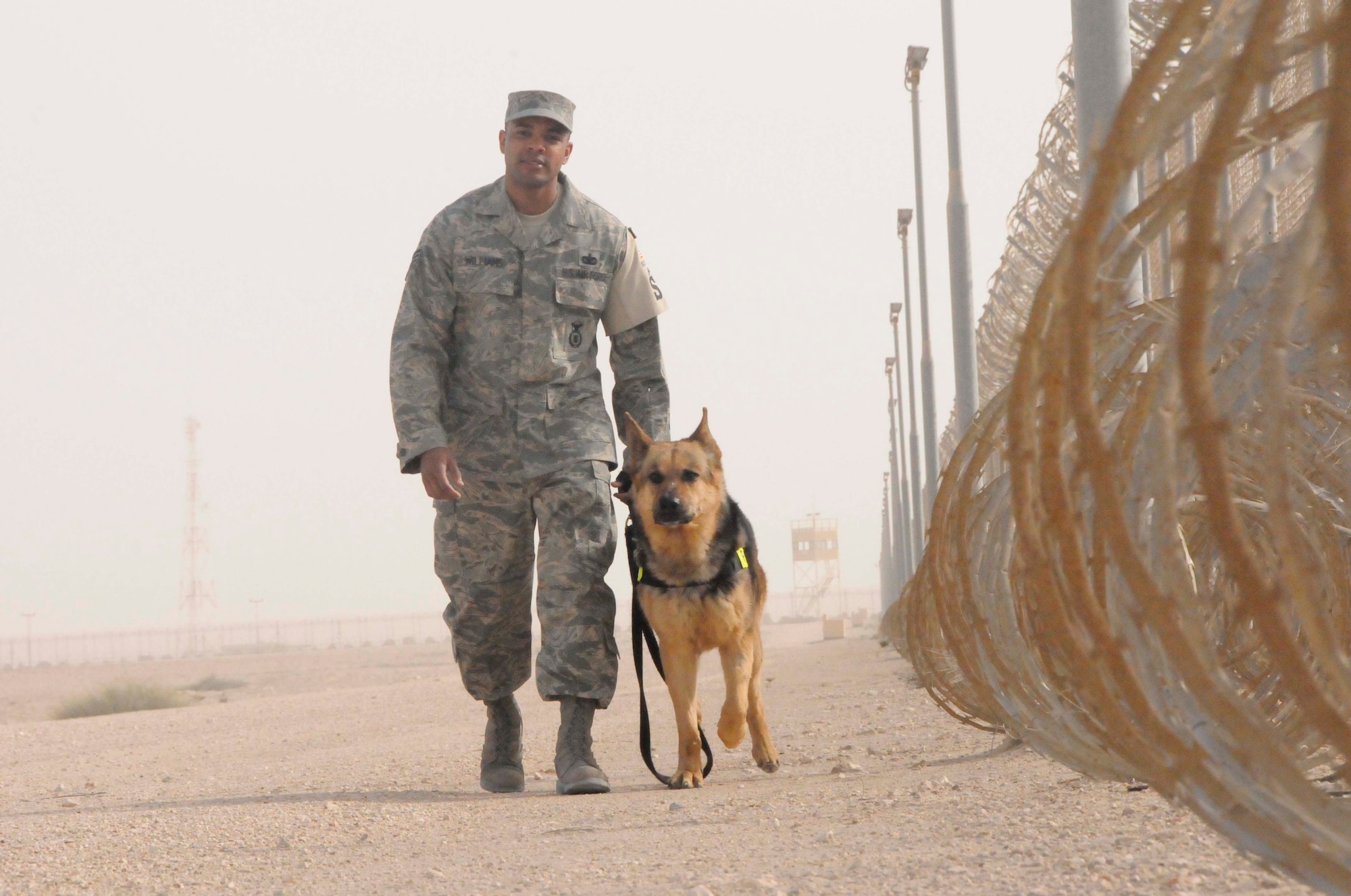SOUTHWEST ASIA--Staff Sgt. Kenneth Williams walks Bruno, a military working dog, out during a perimeter check March 4. Sergeant Williams is a member of the 379th Expeditionary Security Forces Squadron. (U.S. Air Force photo/ Senior Airman 
Domonique Simmons)
