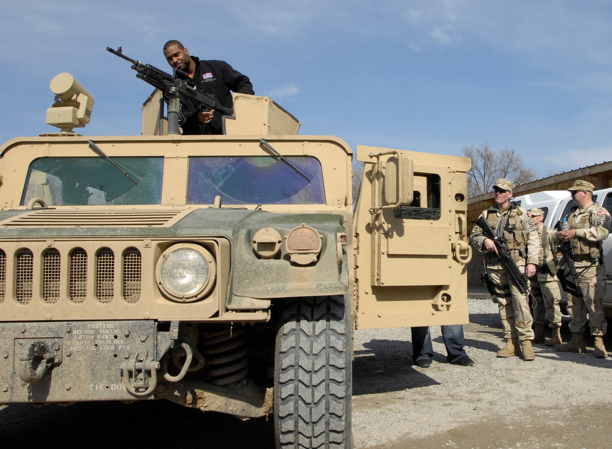 Carolina Panther Mike Rucker checks out a M240B machine gun on a 376th Expeditionary Security Forces Squadron HUMVEE while at Manas AB, Kyrgyzstan, Mar. 4.  Rucker, Chicago Bear Tommie Harris, San Diego Charger Luis Castillo, and sports writer Peter King visited the former Soviet Union country as part of the United Service Organization NFL Tour to see U.S. service members supporting operations in Afghanistan . (U.S. Air Force/SrA Tabitha Kuykendall//released)