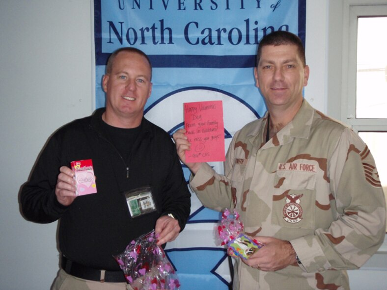 SEYMOUR JOHNSON AIR FORCE BASE, N.C. -- Chief Master Sgt. Douglass Willis (left) and Senior Master Sgt. Donald Knuth enjoy belated Valentine's Day gifts from their home unit, the 916th Civil Engineer Squadron. The two are deployed to Balad Air Base, Iraq along with several other firefighters from the North Carolina Reserve wing.