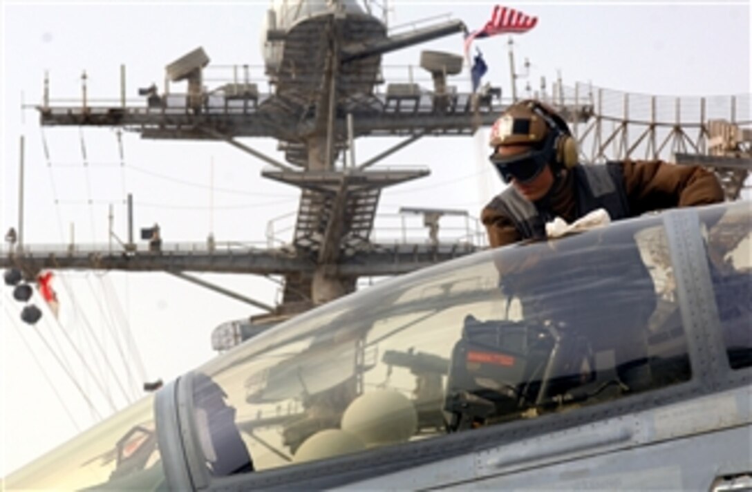 U.S. Air Force Airman Waldemar Martinez cleans the canopy of an F/A-18 Super Hornet on the flight deck of the USS Harry S. Truman, under way in the Persian Gulf. Martinez is assigned to Strike Fighter Squadron 11, March 5, 2008. 
