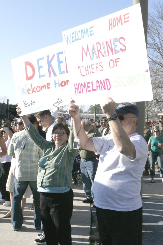 Parents of a returning Marine hold signs welcoming their son home from a deployment to Iraq here March 6. Marines with 2nd Radio Battalion, II Marine Expeditionary Force, returned from a seven-month deployment in support of Operation Iraqi Freedom.