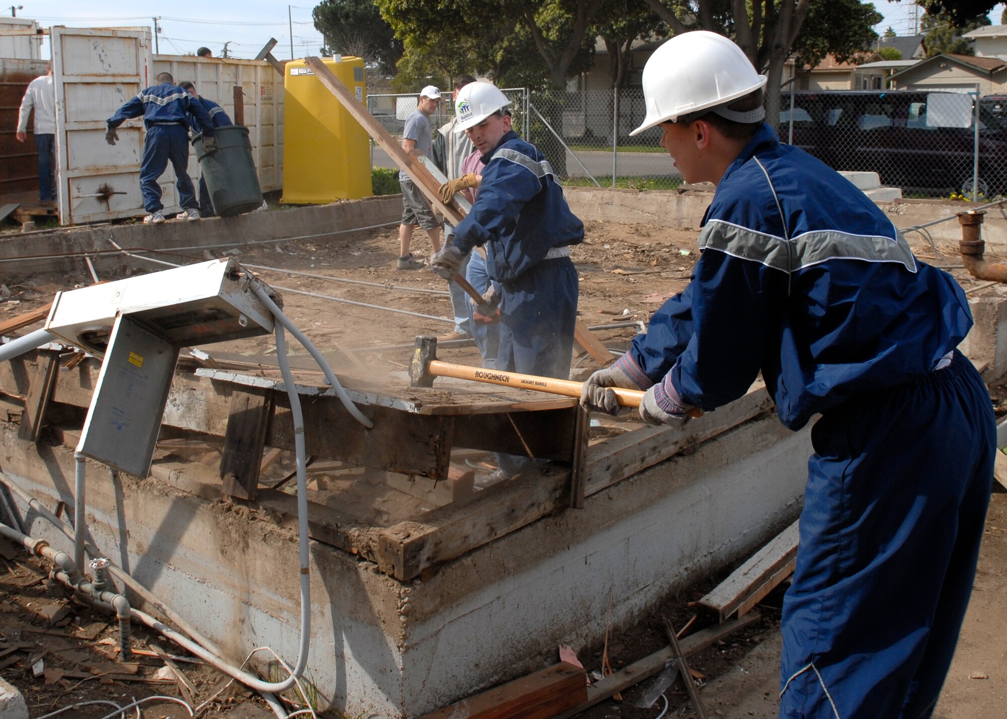 SANTA MARIA, Calif.--  Airman 1st Class Zachary Rossiter and Airman Basic Kyle Palmer destroy the last frame of the house on Mar. 1 while volunteering with Habitat for Humanity. Programs like this allow Airmen stationed at Vandenberg AFB to help rebuild homes in the local community.  Habit for Humanity gives Airmen the opportunity to work with local civilians in building a better community.  (U.S. Air Force photo/Airman 1st Class Andrew Satran)