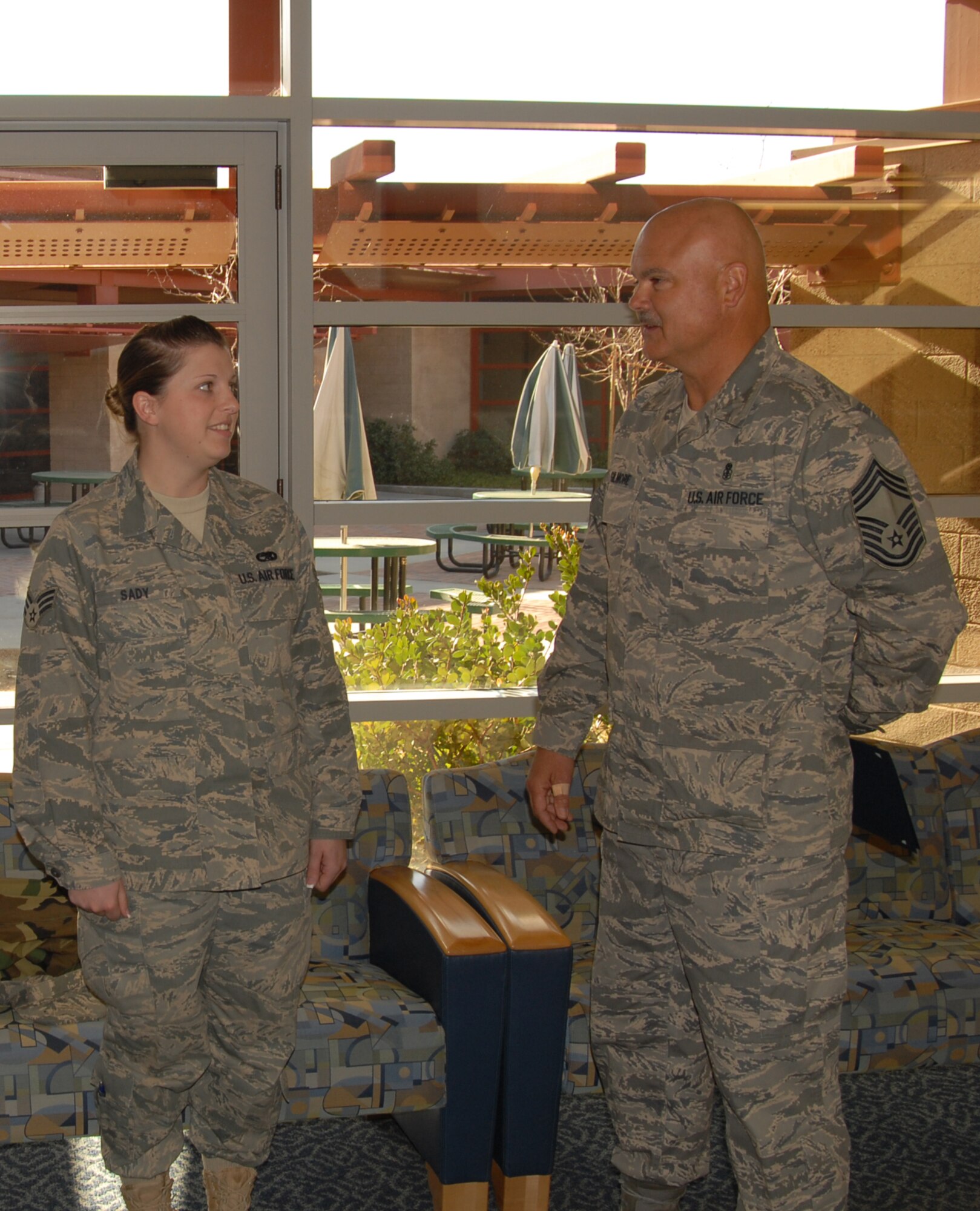 Chief Master Sgt. David Gilmore (right), 95th Medical Group superintendent, talks about the Dare to Soar award to Senior Airman Denay Sady, 412th Maintenance Squadron munitions crew chief. The Dare to Soar award is presented to Airmen for their outstanding actions. Airman Sady received the award for organizing the National Salute to Hospitalized Veterans' Patient visitation recently. (Air Force photo by Airman 1st Class William O’Brien) 
