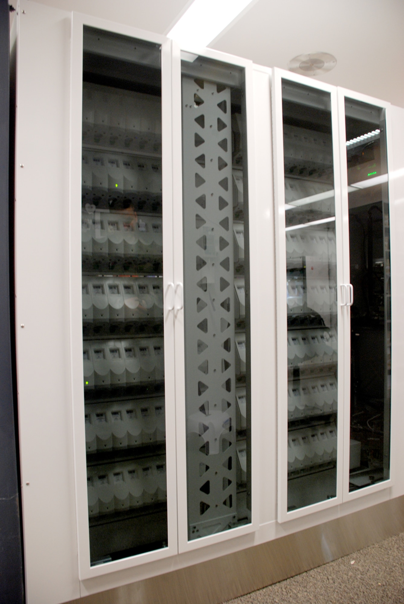 The glass doors secure the many cells inside the RCDS. Each cell represents an individual prescription medicine. The machine counts 140 separate medications.