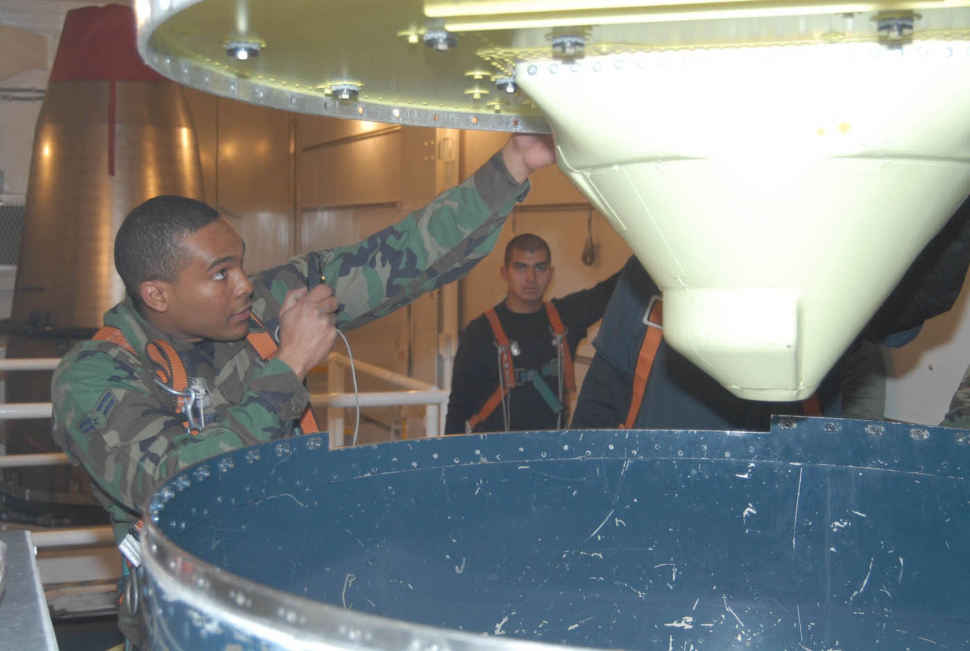 Airman 1st Class Charles Bostic, 90th Missile Maintenance Squadron, inspects the bottom of the mating surface on the missile guidance system in a payload transporter (U.S. Air Force photo by Shelley Raffl).