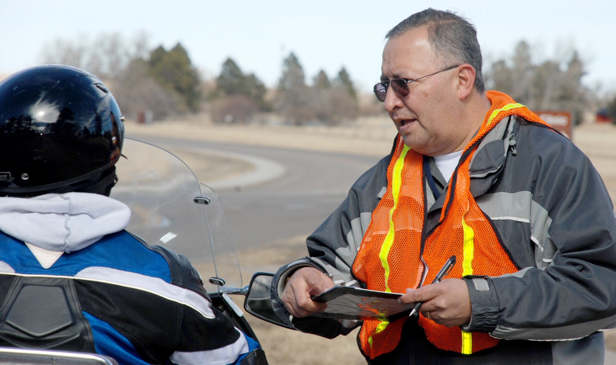Robert Moreno, 90th Contracting Squadron, monitors traffic near the base medical clinic Feb. 27. For one hour a quarter, members from the contracting squadron volunteer to post on the side of a street to ensure drivers are following base traffic laws (U.S. Air Force photo/Airman 1st Class Alex Martinez).
