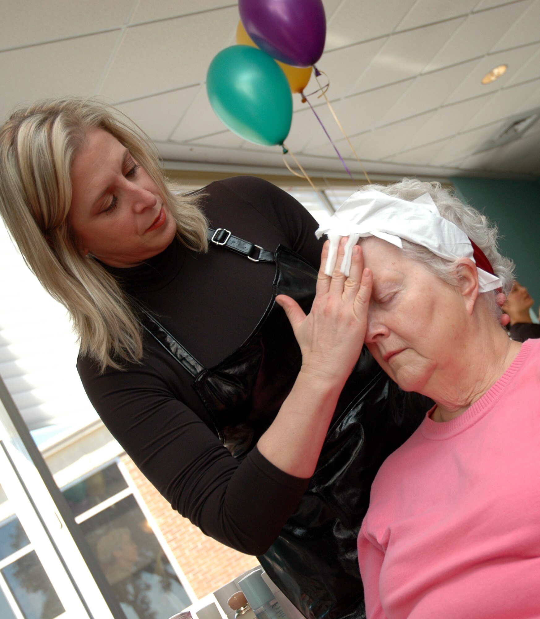 Gina Langley applies a skin care product to Doris Christopherseon at the Health and Fitness Expo sponsored by Eglin's Health and Wellness Center Feb. 27. (U.S. Air Force by Aiman 1st Class Anthony Jennings)