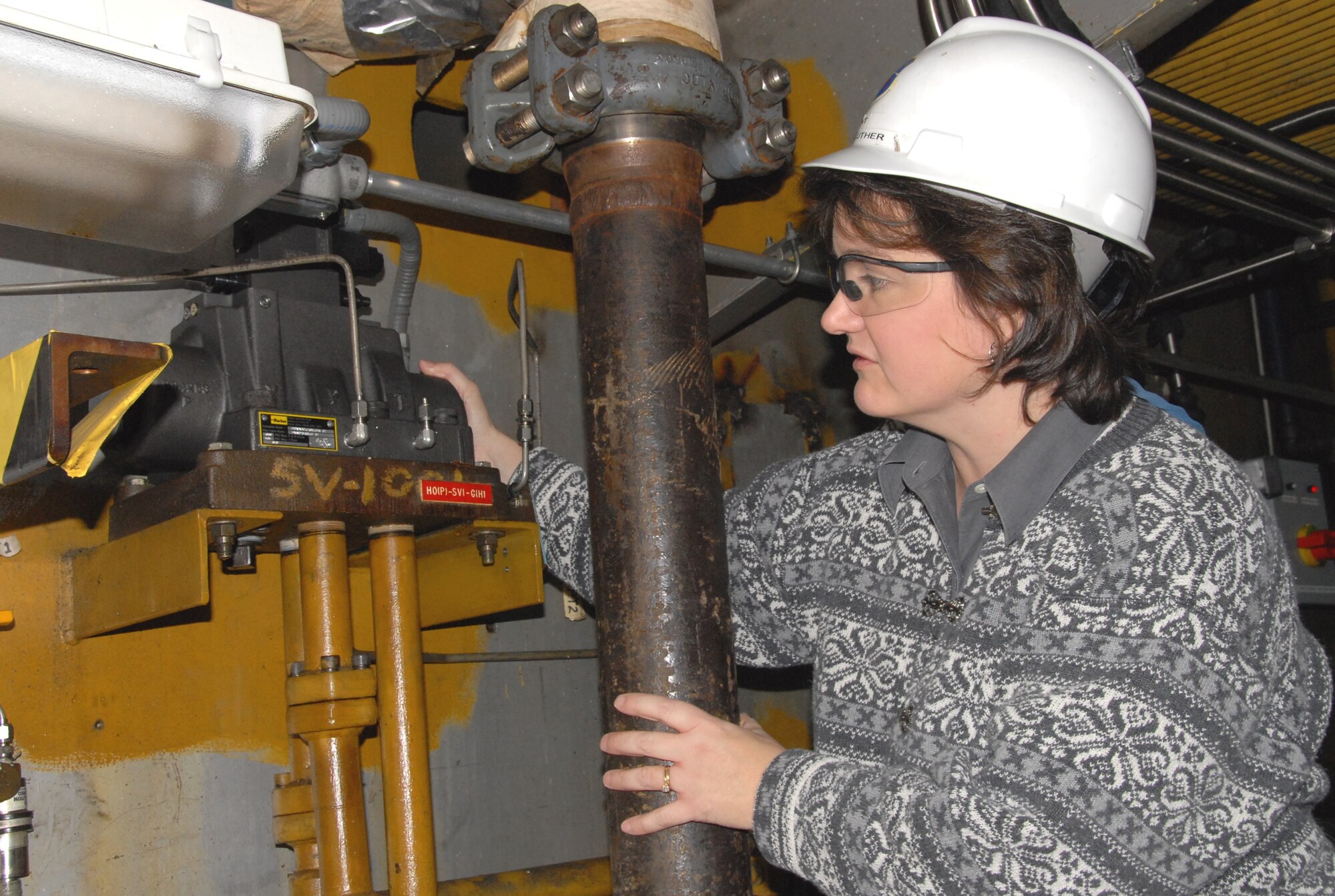 Kim Luther, an Aerospace Testing Alliance Test Operations systems engineer for the center’s 16-foot transonic wind tunnel, inspects a 16T High Angle Automated Sting (HAAS) pitch blocking valve. She is in the process of completing a job that replaced four of these valves due to performance issues. The valves have been in place for more than 20 years and had never been removed, rebuilt or replaced. (Photo by David Housch)