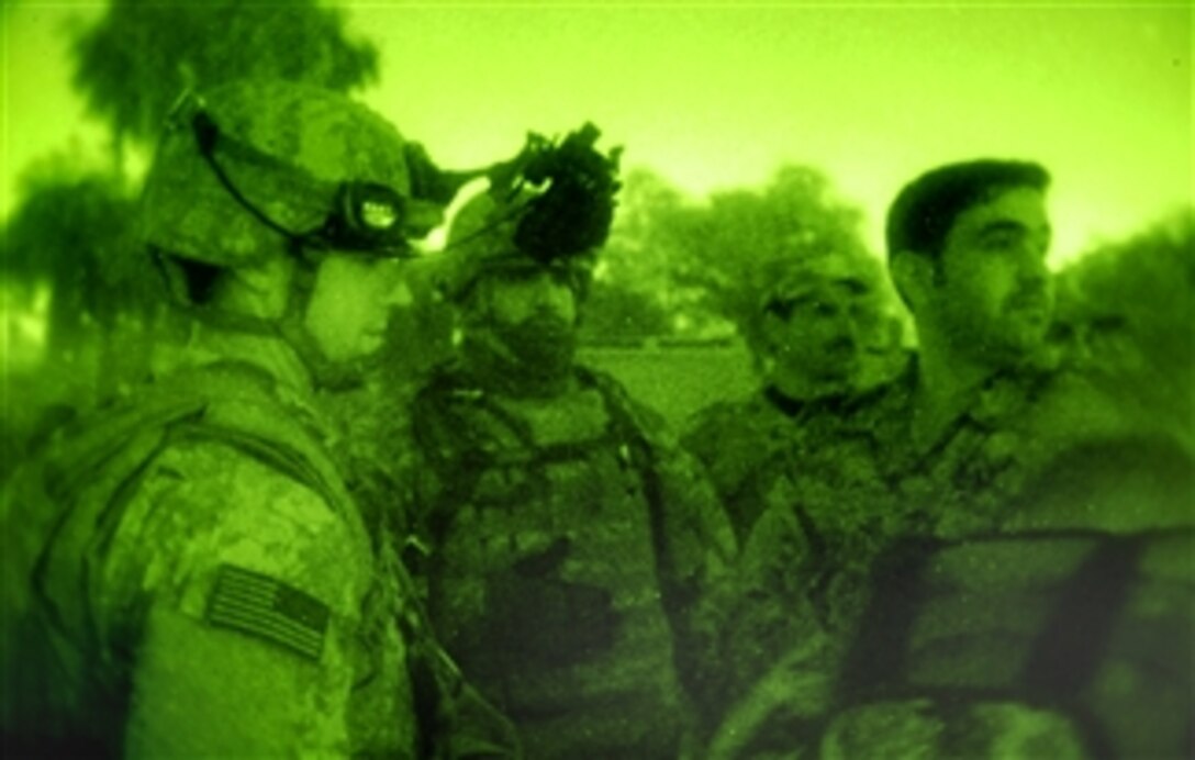 U.S. Army 1st Lt. Jeff Nelson talks to members of the Iraqi National Police about their traffic checkpoint in the Beida neighborhood of Baghdad, Iraq, Feb. 28, 2008, after they were attacked by small arms fire.  Nelson, left, is assigned to the 4th Infantry Division, 3rd Brigade Combat Team, 68th Armor Regiment, 1st Battalion.