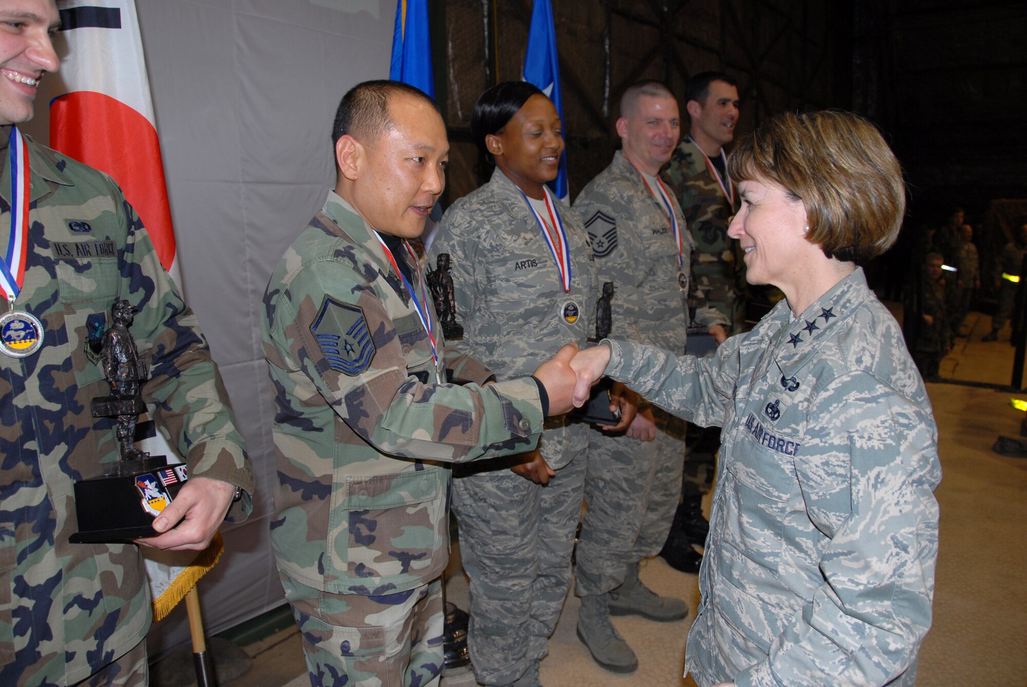 OSAN AIR BASE, Republic of Korea—Lt. Gen. Terry L. Gabreski, Air Force Materiel Command vice commander, and guest speaker at the 51st Fighter Wing’s Maintenance Professional of the Year banquet March 7, presents her commander’s coin and congratulates Master Sgt. Erik An who was recognized as the Maintenance Support Systems Performer of the Year, Supervisor-Manager category. During her speech to 51st Maintenance Group Airmen, General Gabreski said it was important for aircraft maintainers to exhibit Air Force core values when performing their daily missions of aircraft generation. When pilots perform a walk-around inspection of their aircraft, they finish by reviewing the aircraft forms, checking for the "X" and crew chief's signature certifying that the aircraft is ready for flight. The "X" and signature on the forms also signify the aircraft crew chief's integrity and provides a mutual bond of trust between the crew chief and the pilot, said the general. Additionally, General Gabreski presented Maintenance Professional of the Year awards to 51st Maintenance Group Airmen. (U.S. Air Force photo/Senior Master Sgt. Marvin Krause)  