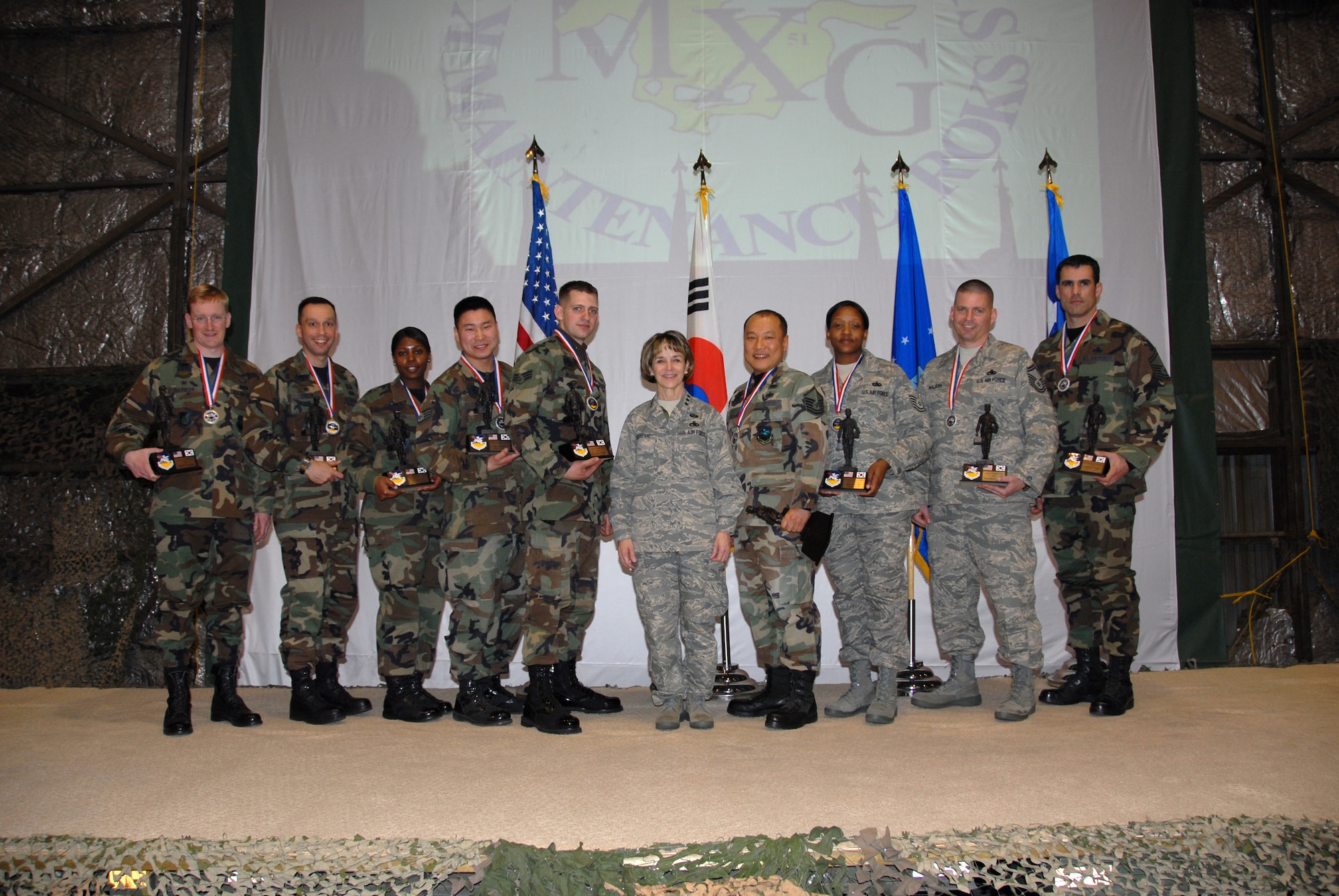 OSAN AIR BASE, Republic of Korea—Lt. Gen. Terry L. Gabreski, Air Force Materiel Command vice commander, and guest speaker at the 51st Fighter Wing’s Maintenance Professional of the Year banquet March 7, poses with the 51st Fighter Wing’s Maintenance Professional of the Year award winners . During her speech to 51st Maintenance Group Airmen, General Gabreski said it was important for aircraft maintainers to exhibit Air Force core values when performing their daily missions of aircraft generation. When pilots perform a walk-around inspection of their aircraft, they finish by reviewing the aircraft forms, checking for the "X" and crew chief's signature certifying that the aircraft is ready for flight. The "X" and signature on the forms also signify the aircraft crew chief's integrity and provides a mutual bond of trust between the crew chief and the pilot, said the general. Additionally, General Gabreski presented Maintenance Professional of the Year awards to 51st Maintenance Group Airmen. (U.S. Air Force photo/Senior Master Sgt. Marvin Krause)