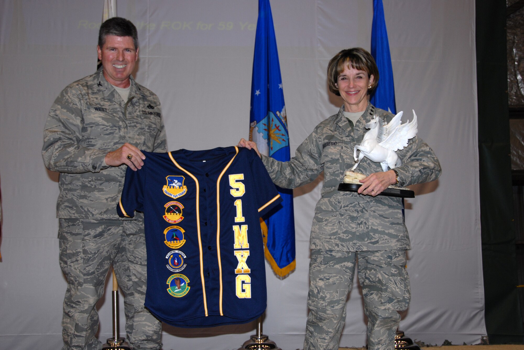 OSAN AIR BASE, Republic of Korea—Lt. Gen. Terry L. Gabreski, Air Force Materiel Command vice commander, (right), receives a 51st Fighter Wing “Mustang” horse statue and 51st Maintenance Group unit jersey from Col. Robert West, 51st Maintenance Group commander.  Col. West presented the mementos to General Gabreski for being the guest speaker at the 51st Fighter Wing’s Maintenance Professional of the Year banquet March 7.  General Gabreski said it was important for aircraft maintainers to exhibit Air Force core values when performing their daily missions of aircraft generation. When pilots perform a walk-around inspection of their aircraft, they finish by reviewing the aircraft forms, checking for the "X" and crew chief's signature certifying that the aircraft is ready for flight. The "X" and signature on the forms also signify the aircraft crew chief's integrity and provides a mutual bond of trust between the crew chief and the pilot, said the general.  Additionally, General Gabreski presented Maintenance Professional of the Year awards to 51st Maintenance Group Airmen.  (U.S. Air Force photo/Senior Master Sgt. Marvin Krause)