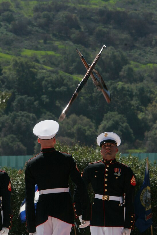Cpl. Anthony C. Hill, Silent Drill Platoon senior rifle inspector, exchanges highly-polished M1 Garand rifles during the platoon's performance here March 7. They perform their routine for audiences across the country with the high level of professionalism and precision the Marine Corps is known for.