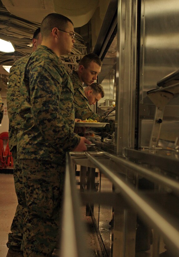 Marines get food from the main galley aboard USS San Antonio (LPD-17).  Elements of the 26th Marine Expeditionary Unit and Battalion Landing Team 3/8 are aboard the San Antonio to provide support to the ship?s operational evaluation, which will determine the ship?s readiness to carry Marines into future operations.  An additional 1800 daily meals truly put the galley through its paces.