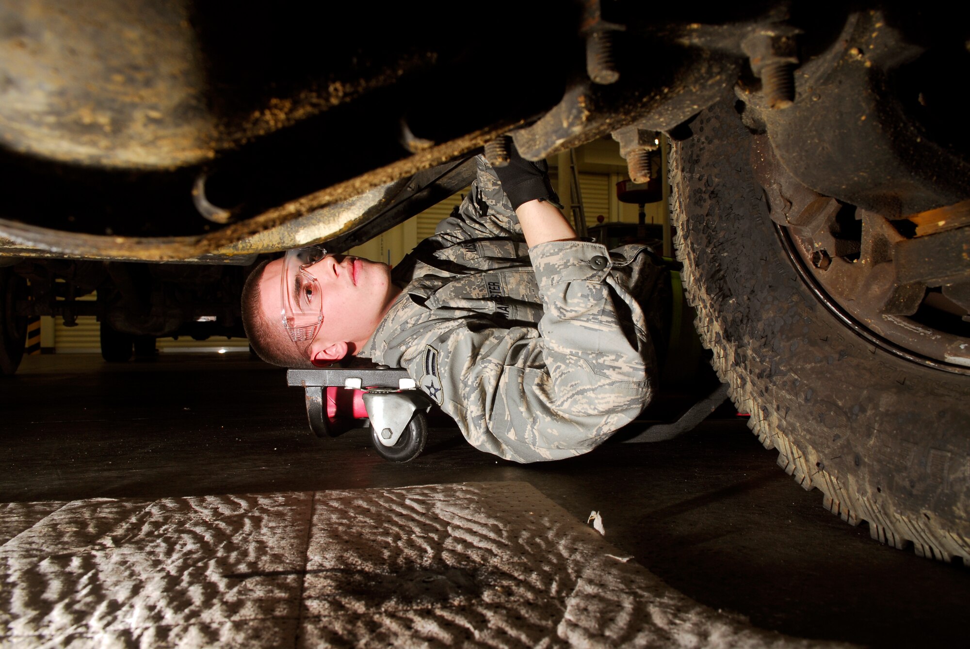 Airman 1st Class Derek Manchester, 18th Logistics Readiness Squadron, inspects the undercarriage of an F-350 truck, prior to replacing a brake line during the 2008 Pacific Air Forces Operational Readiness Inspection at Kadena Air Base, Japan, March 11, 2008. PACAF is conducting the inspection from March 9 to 15 to validate the mission readiness of the 18th Wing. (U.S. Air Force photo/Staff Sgt. Joshua J. Garcia) (Released)