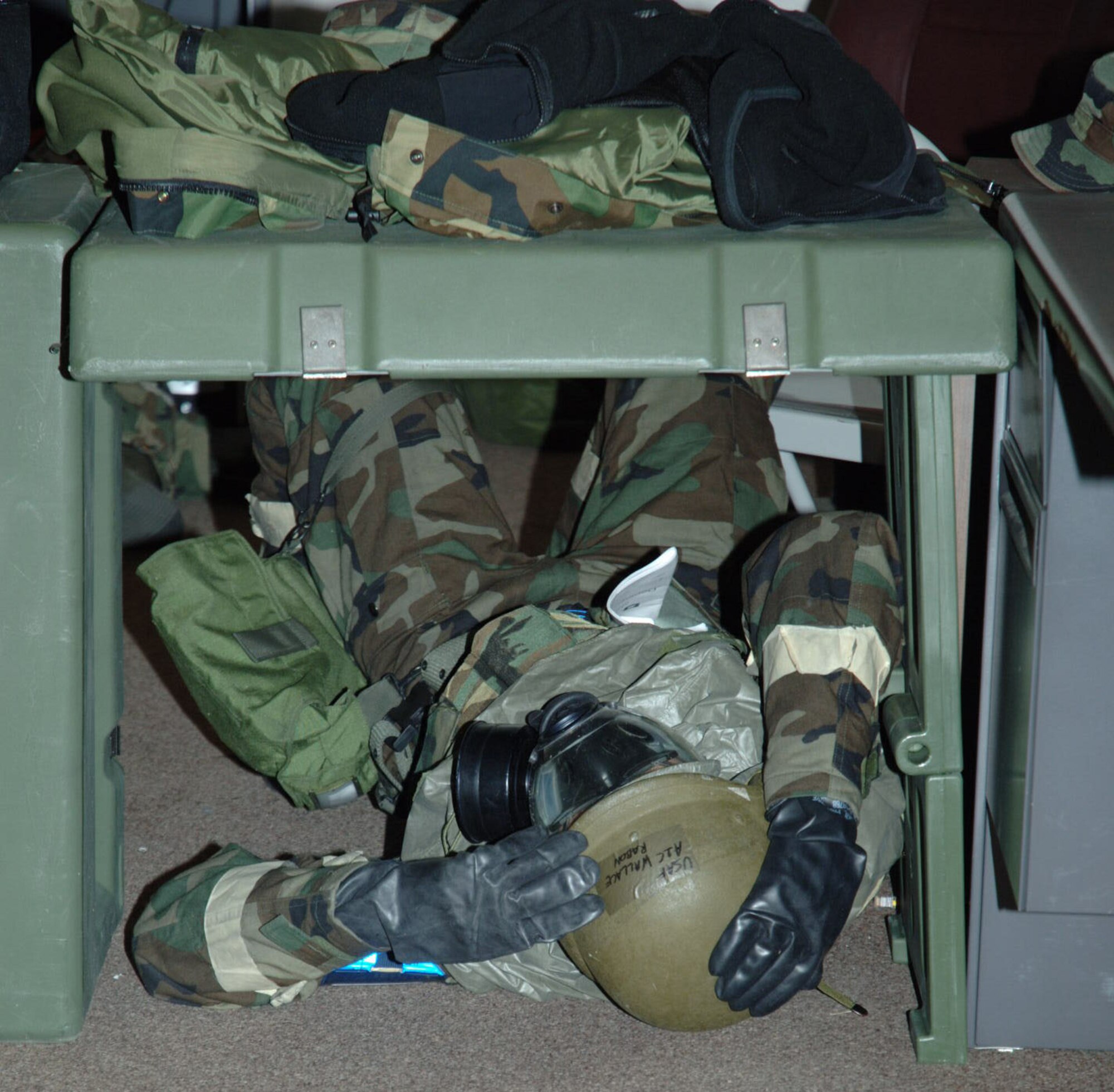 MCCONNELL AIR FORCE BASE, Kan. -- Airman 1st Class Rabon Wallace, 22nd Communications Squadron, seeks shelter under a harden structure March 7, during an Ability to Survive and Operate exercise here. While the attack alarm is “Red”, participating 22nd Air Refueling Wing members and 931st Air Refueling Group reservist took immediate cover wearing full Mission Oriented Protective Posture gear. (photo by Tech. Sgt. Jason Schapp, 931st Public Affairs)