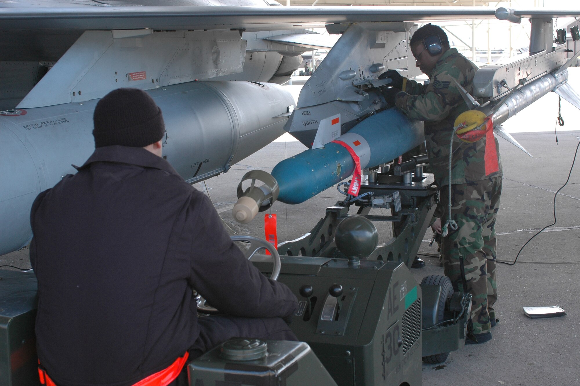 (From left to right) Airman 1st Class Chris Ladner, Staff Sgt. Donald Craig and Airman 1st Class Amanda Chadwick (not visible), all 34th Fighter Squadron, load a guided bomb unit onto an F-16 Fighting Falcon here Feb. 6. (U.S. Air Force photo by Senior Airman Brok McCarthy)
