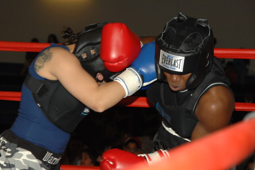 Airman 1st Class Krystal Macatol, 49th Maintenance Squadron, and Staff Sgt. Genese Williams, 49th Materiel Maintenance Support Squadron, lock up during a match March 7 at Holloman Air Force Base, N.M. Sergeant Williams won the three round fight by decision. (U.S. Air Force photo/Airman 1st Class Jamal D. Sutter)